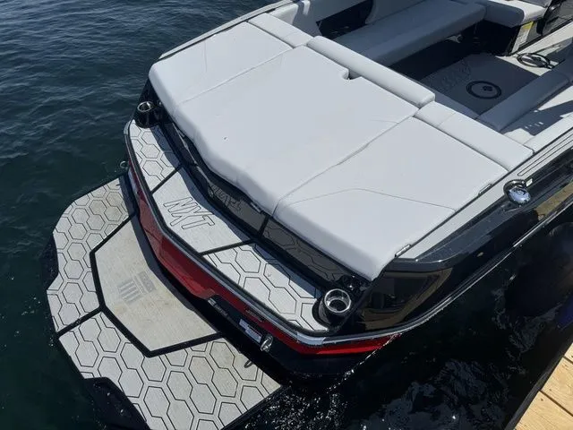 Slide: The Image of 2024 MasterCraft NXT23 boat with sleek design and spacious seating on the water. - 9