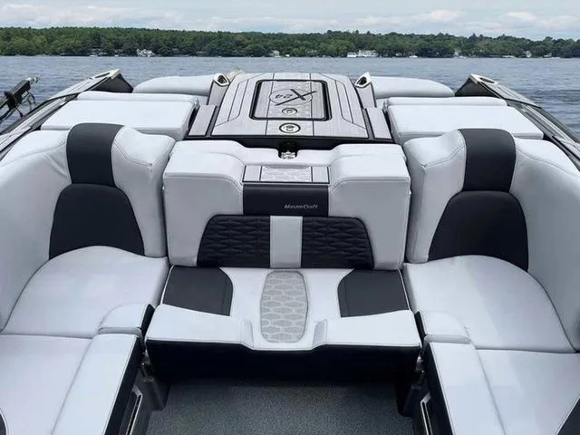 Slide: The Image of 2024 MasterCraft X24 boat interior with luxurious seating on a lake. - 12