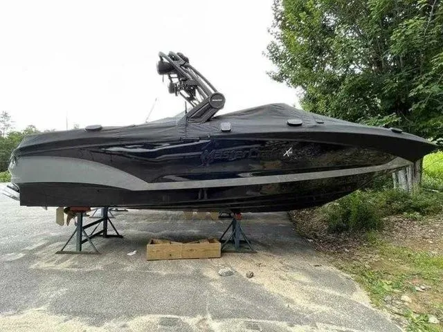 Slide: The Image of 2024 MasterCraft X24 boat on stands, covered, outdoors. - 23