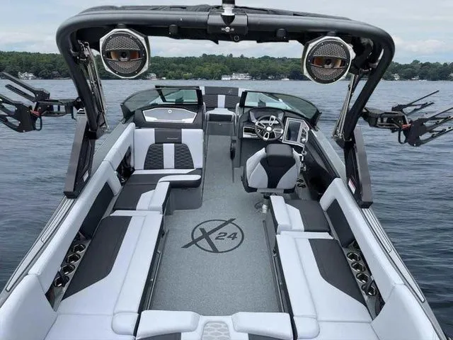 Slide: The Image of 2024 MasterCraft X24 boat interior with sleek seating and advanced controls on a serene lake. - 3