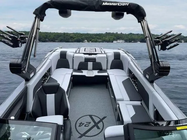 Slide: The Image of 2024 MasterCraft X24 boat interior with sleek seating on a lake. - 6