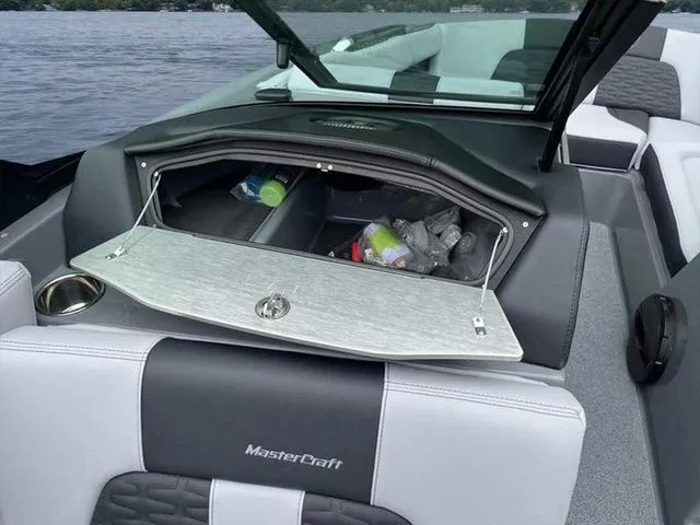 Slide: The Image of 2024 MasterCraft X24 boat interior with open storage compartment, revealing various items. - 9