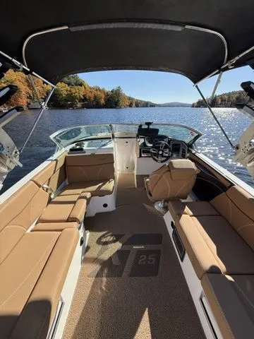 Slide: The Image of 2019 MasterCraft XT25 boat interior on a scenic lake with autumn foliage. - 6
