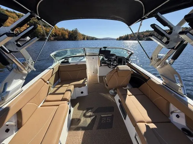 Slide: The Image of 2019 MasterCraft XT25 boat interior on a scenic lake with autumn foliage. - 7