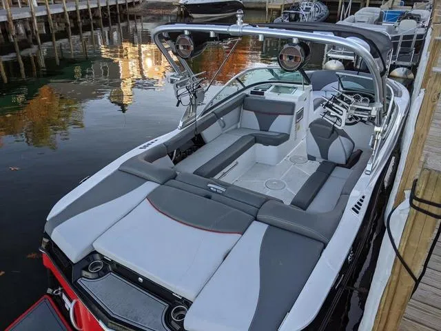 Slide: The Image of 2019 MasterCraft XT22 boat with sleek seating and modern design docked by the water. - 13