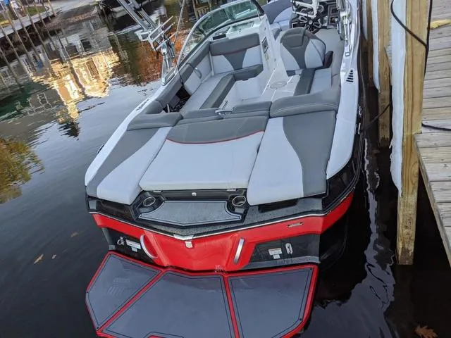 Slide: The Image of 2019 MasterCraft XT22 boat docked, featuring sleek gray and red design with spacious seating. - 3