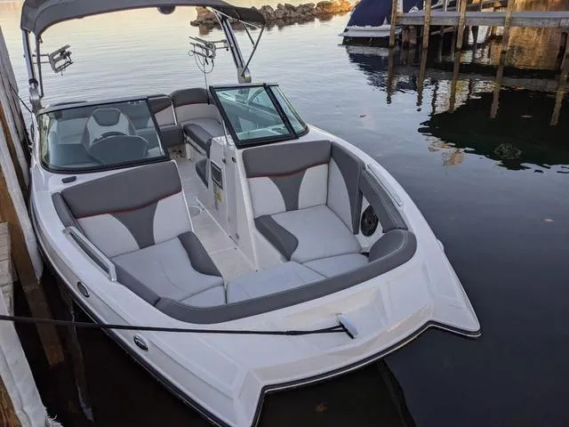 Slide: The Image of 2019 MasterCraft XT22 boat docked on calm water, featuring sleek seating and modern design. - 4