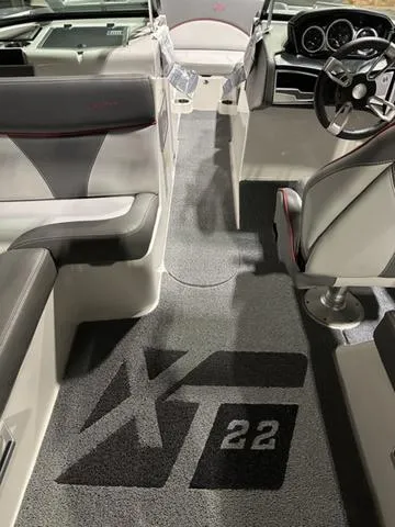 Slide: The Image of 2019 MasterCraft XT22 boat interior with sleek seating and modern dashboard design. - 7