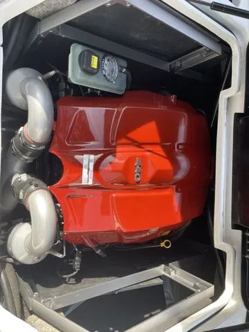 Slide: The Image of 2017 Malibu 24 MXZ engine compartment with red cover and dual exhaust pipes. - 21