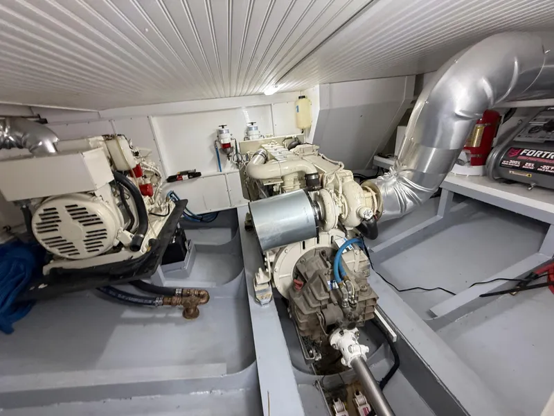 Slide: The Image of Engine room of a 2009 Custom Dutch Canal Barge, featuring mechanical components and piping. - 21