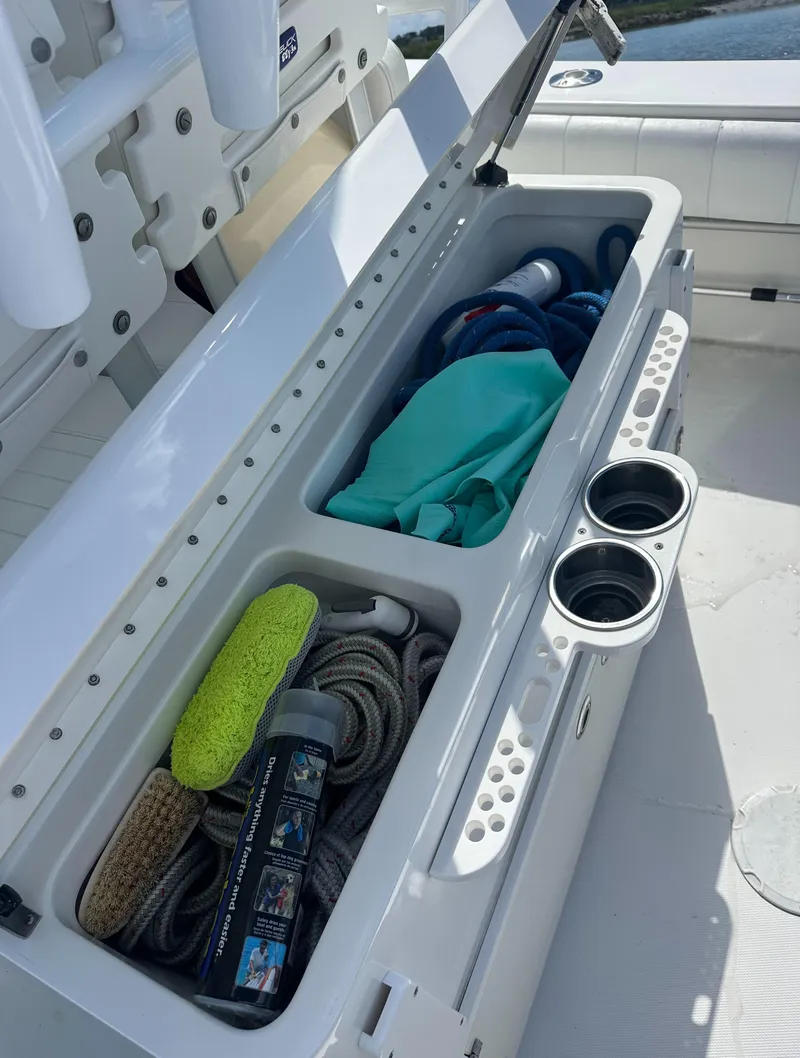 Slide: The Image of Storage compartment on a 2009 Regulator 32FS boat, containing ropes and cleaning supplies. - 10