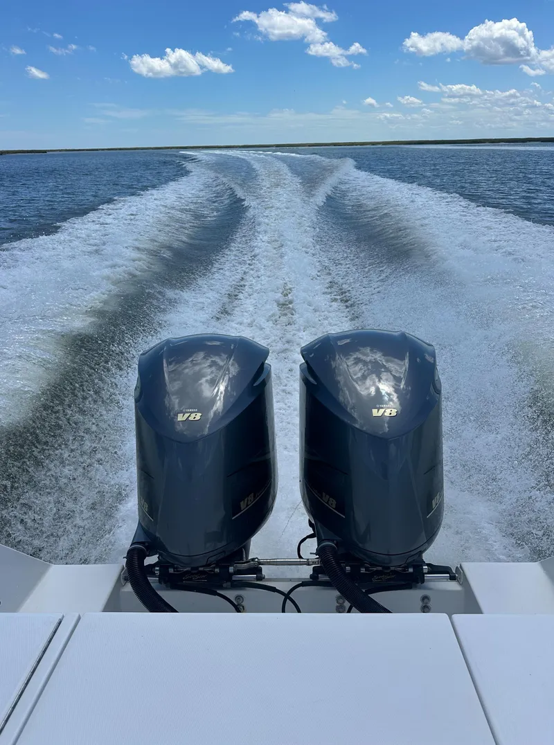 Slide: The Image of 2009 Regulator 32FS boat with twin outboard engines cruising on open water. - 11