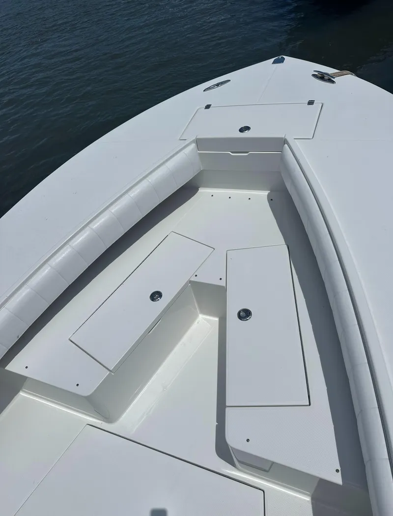 Slide: The Image of 2009 Regulator 32FS boat bow with storage compartments on calm water. - 13