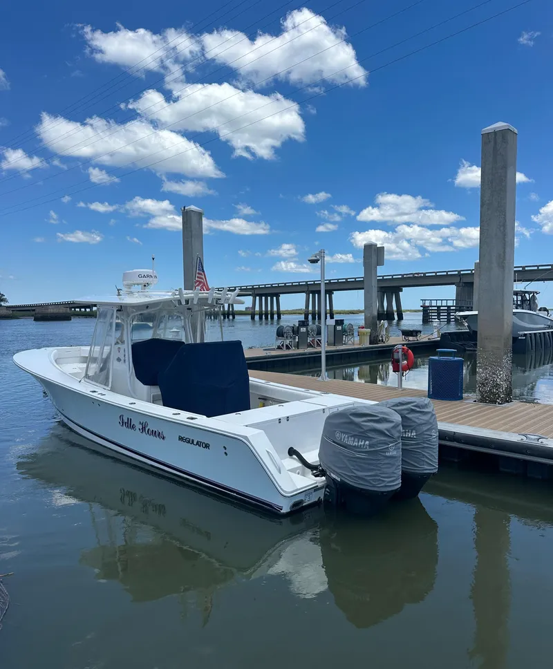Slide: The Image of 2009 Regulator 32FS boat docked at marina under blue sky. - 3