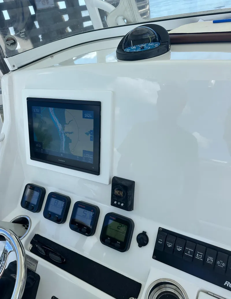 Slide: The Image of Control panel of a 2009 Regulator 32FS boat with navigation and instrument displays. - 8