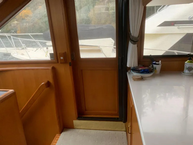 Slide: The Image of Interior view of a 1997 Ocean Alexander 548 yacht, featuring wooden paneling and a countertop. - 12