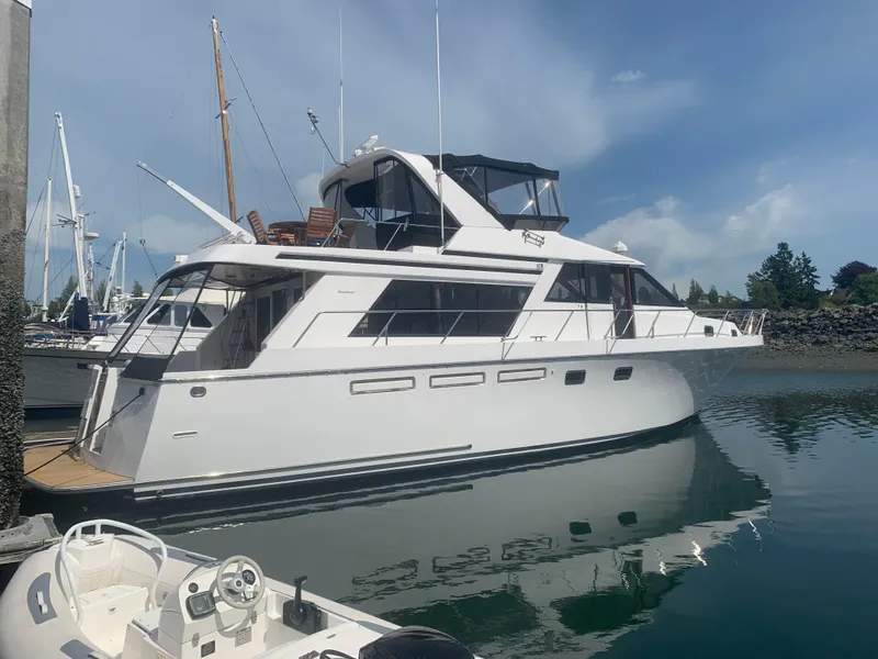 Slide: The Image of 1997 Ocean Alexander 548 yacht docked in a marina under a clear blue sky. - 2