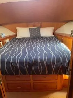 Slide: The Image of Cozy bedroom in 1997 Ocean Alexander 548 yacht with patterned bedding and wooden cabinetry. - 21