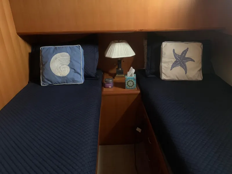 Slide: The Image of Twin beds with nautical-themed pillows in a 1997 Ocean Alexander 548 yacht cabin. - 22