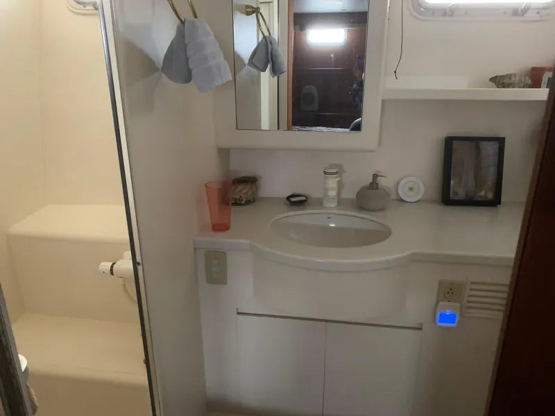 Slide: The Image of Bathroom interior of a 1997 Ocean Alexander 548 yacht, featuring a sink and shower area. - 24