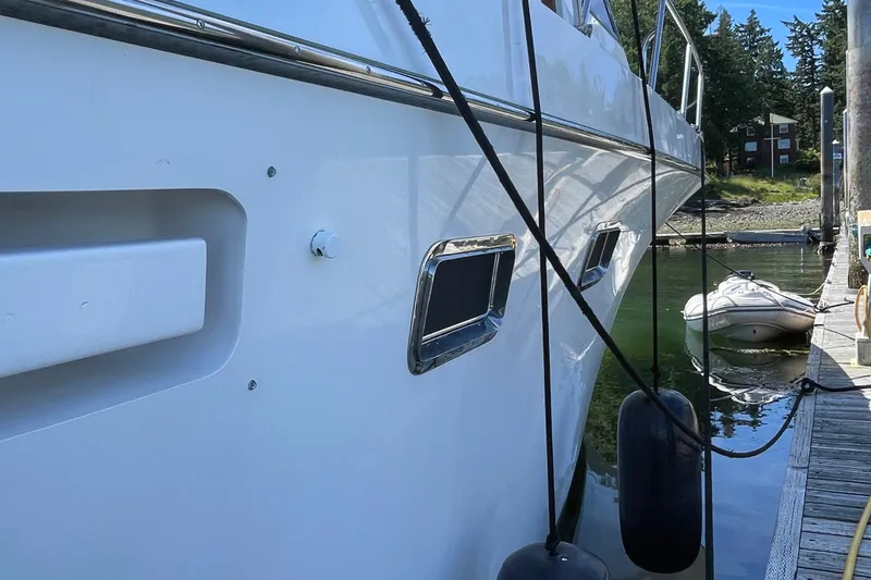 Slide: The Image of Side view of 1997 Ocean Alexander 548 yacht docked with fenders and ropes. - 27