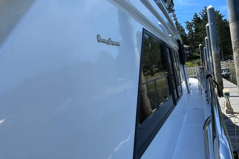 Slide: The Image of 1997 Ocean Alexander 548 yacht docked, showcasing sleek white exterior and reflective windows. - 30