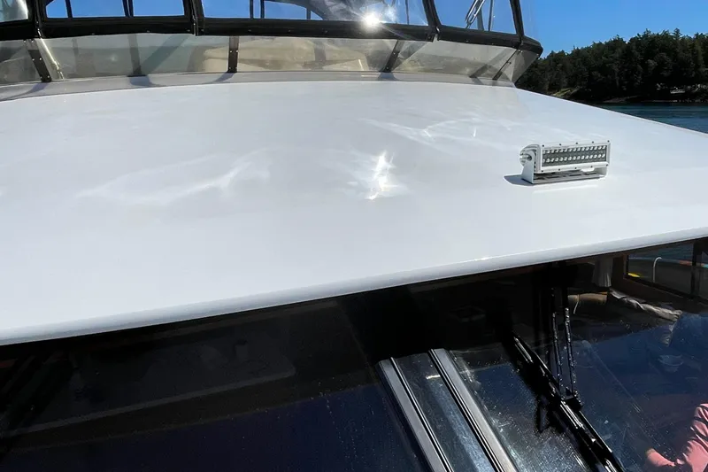 Slide: The Image of 1997 Ocean Alexander 548 yacht deck with windshield and light, under clear blue sky. - 31