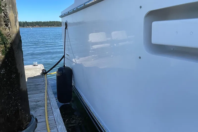 Slide: The Image of Side view of a 1997 Ocean Alexander 548 yacht docked by a pier. - 32