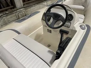 Slide: The Image of 1997 Ocean Alexander 548 boat helm with steering wheel and controls, featuring white seating. - 41