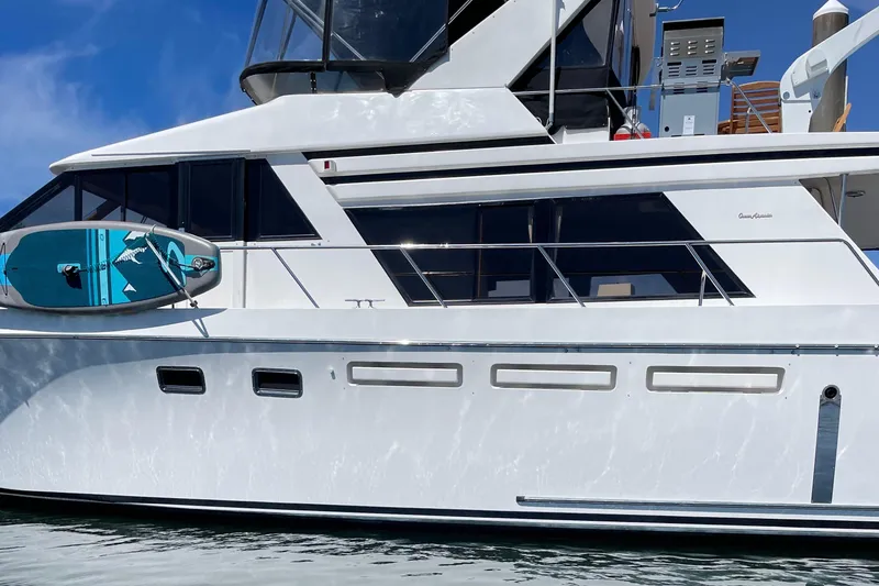 Slide: The Image of 1997 Ocean Alexander 548 yacht with paddleboard, docked on a sunny day. - 6