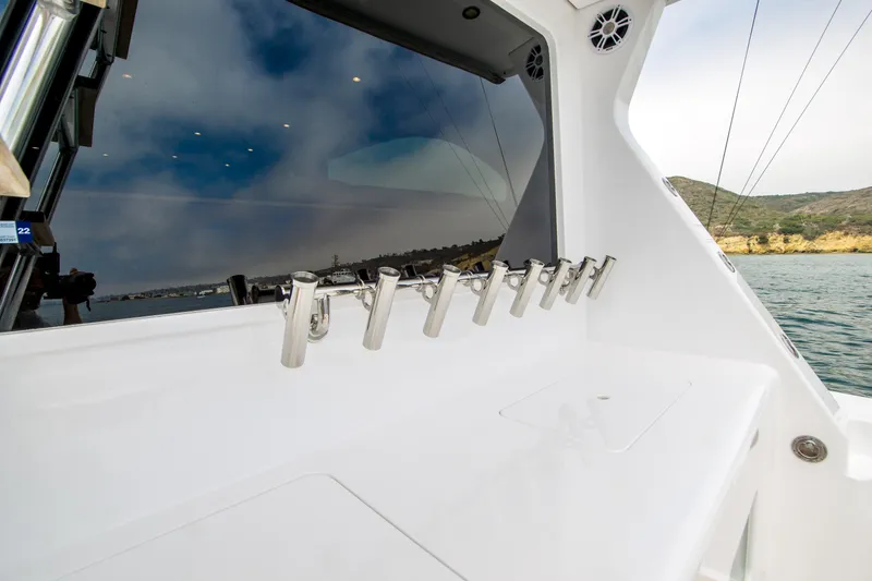 Slide: The Image of 2003 Donzi 65 Convertible yacht with rod holders, sleek design, and ocean view. - 10