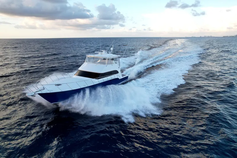 Slide: The Image of 2003 Donzi 65 Convertible yacht cruising on open ocean under cloudy sky. - 2
