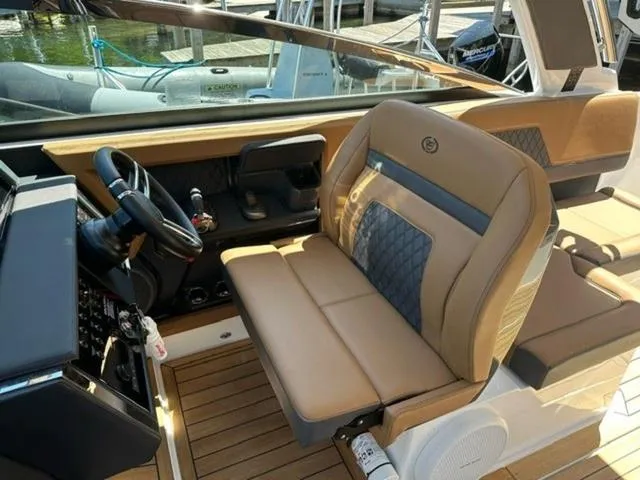 Slide: The Image of 2024 Cobalt R33 Surf boat interior with tan leather seating and modern dashboard. - 10