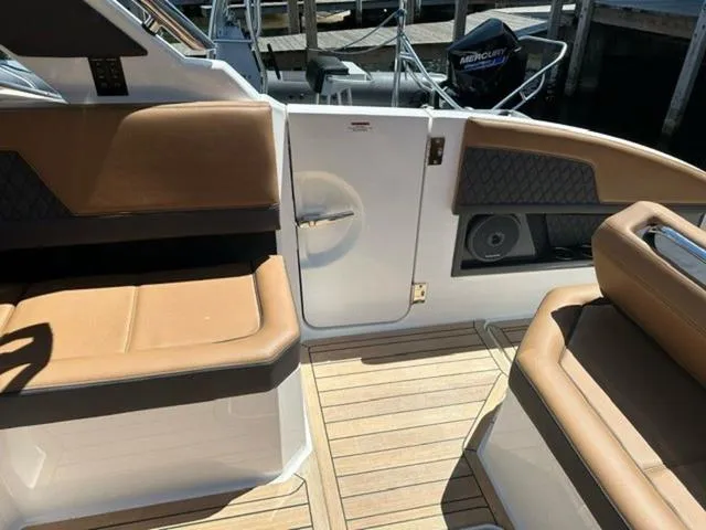 Slide: The Image of 2024 Cobalt R33 Surf boat interior with tan seating and wood flooring. - 14