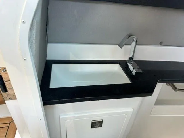 Slide: The Image of 2024 Cobalt R33 Surf boat interior sink with modern faucet and sleek design. - 3