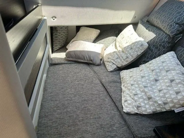 Slide: The Image of 2024 Cobalt R33 Surf interior with gray cushions and pillows in a cozy seating area. - 6