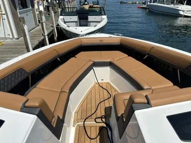 Slide: The Image of 2024 Cobalt R33 Surf boat with tan seating, docked at a marina. - 8