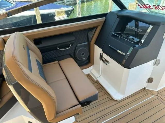 Slide: The Image of 2024 Cobalt R33 Surf boat interior with tan seating and sleek dashboard design. - 9
