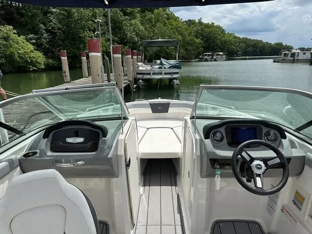 Slide: The Image of 2023 Chaparral 23 SSi boat interior with dashboard, steering wheel, and lake view. - 5