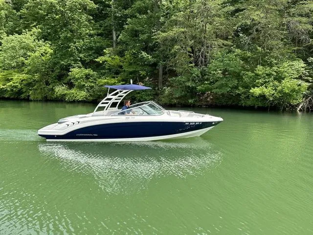 Slide: The Image of 2023 Chaparral 23 SSi boat cruising on a serene green lake. - 9