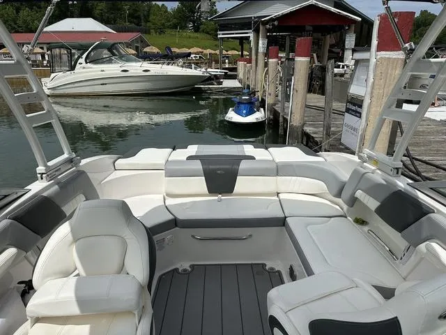 Slide: The Image of 2023 Chaparral 23 SSi boat interior at a marina with other boats docked nearby. - 4