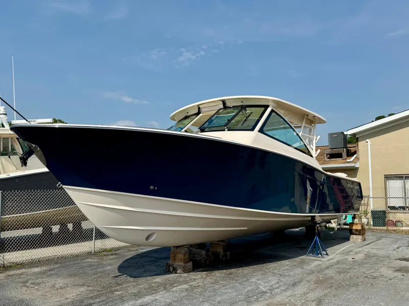 The Image of 2025 Grady-White Freedom 375 boat on dry dock, blue hull, sunny day. - 1