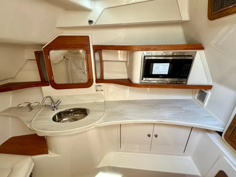 Slide: The Image of 2025 Grady-White Freedom 375 boat interior with kitchenette, sink, and microwave. - 14