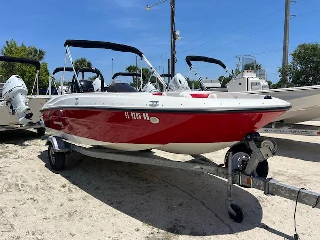 The Image of 2016 Bayliner Element XL boat in red, parked on a trailer under a clear blue sky. - 0