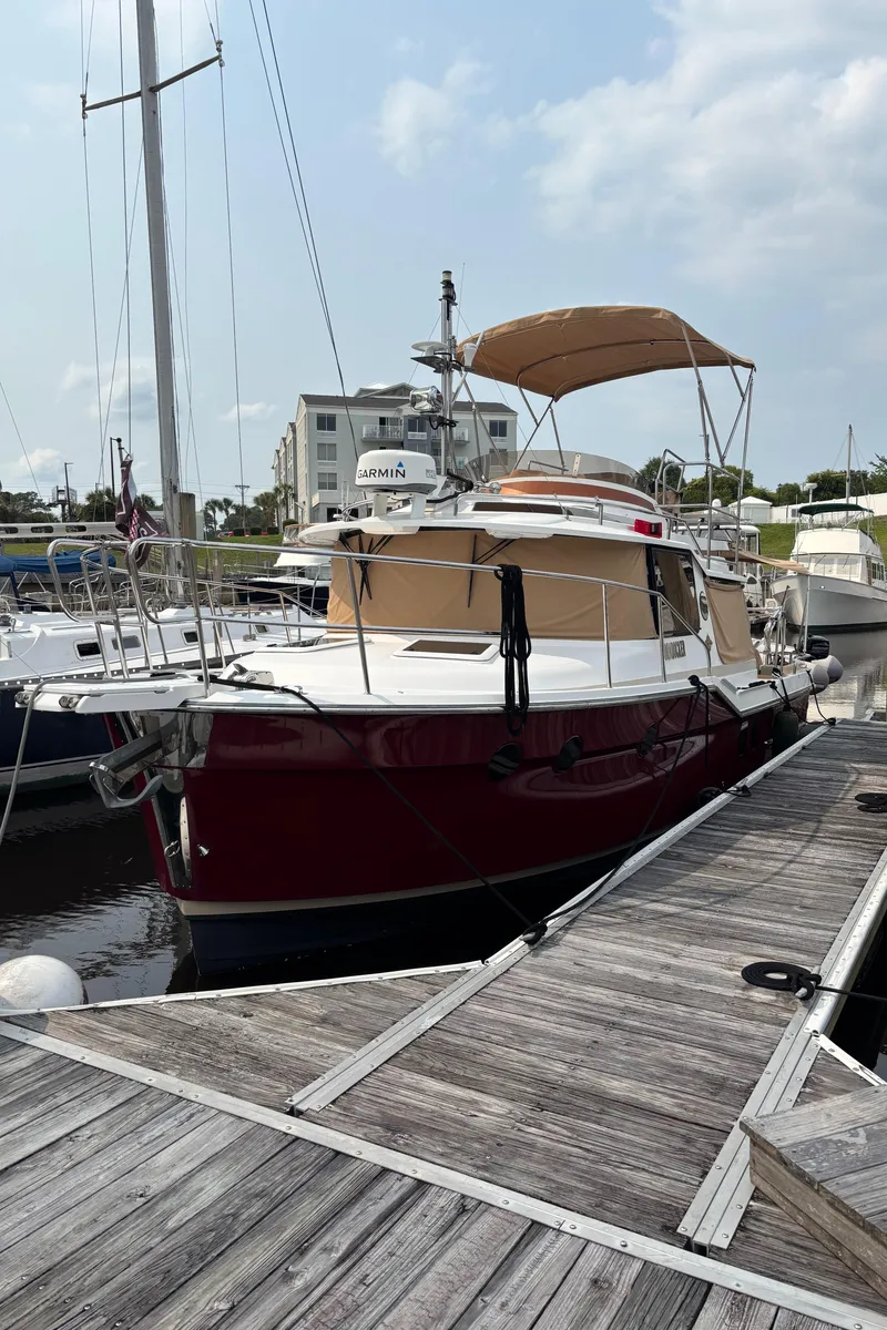Slide: The Image of 2019 Ranger Tugs R-29 CB docked at marina under cloudy sky. - 2