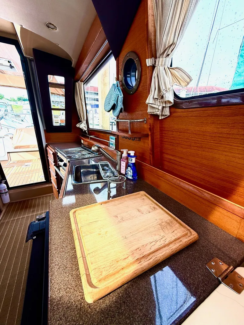 Slide: The Image of 2019 Ranger Tugs R-29 CB interior kitchen with wooden cabinetry and countertop. - 29