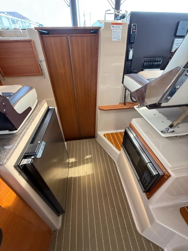 Slide: The Image of 2019 Ranger Tugs R-29 CB interior with wood accents and modern appliances. - 32