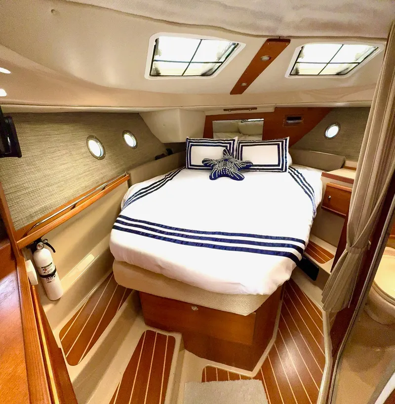 Slide: The Image of 2019 Ranger Tugs R-29 CB cabin interior with bed, portholes, and nautical decor. - 36