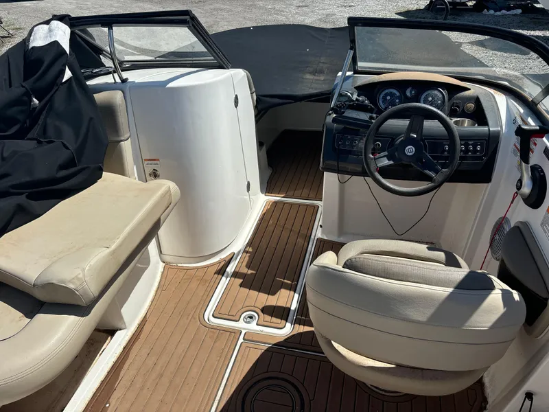 Slide: The Image of 2016 Bayliner 215 Deck Boat interior with steering wheel and seating. - 14