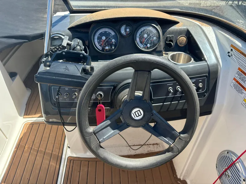 Slide: The Image of 2016 Bayliner 215 Deck Boat dashboard with steering wheel and instrument panel. - 15